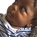 a close up of a baby wearing a striped shirt