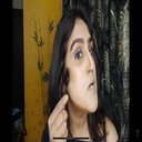 a woman with long black hair wearing a black top