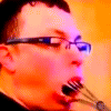 a man wearing glasses and holding a pair of scissors in his mouth