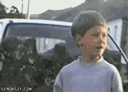 a young boy standing in front of a white truck