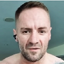 a man with no shirt on taking a selfie