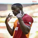 a man in a red and orange shirt holding his hand up to his ear