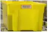 a yellow plastic container sitting on top of a conveyor belt