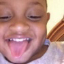 a little boy with his eyes closed and his tongue out