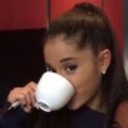 a young girl drinking from a white cup