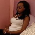 a woman in a white tank top sitting on a bed