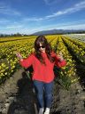 a woman standing in a field of yellow flowers