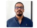 a man with glasses and a beard wearing a blue shirt