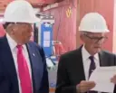 two men in suits and hard hats standing next to each other