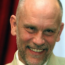 a man with a bald head wearing a suit and tie