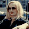 a woman with blonde hair and sunglasses sitting in a car