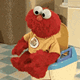 a red stuffed animal sitting on top of a toilet