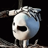 a white mask with black eyes and hands