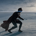a man in a cape and mask riding a snowboard