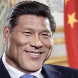 a close up of a person wearing a suit and tie