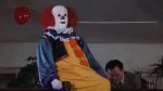 a creepy clown sitting on a chair in a room