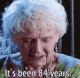 an old woman with white hair is looking at her cell phone