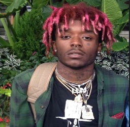 a man with pink dreadlocks wearing a green jacket