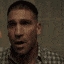 a man in a plaid shirt is looking at the camera