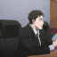 a man in a suit sitting at a desk