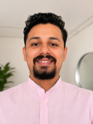 a man with a beard and a pink shirt
