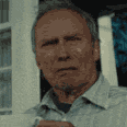 a man in a shirt and tie standing in front of a window