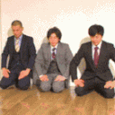 a group of men in suits sitting on the floor