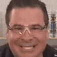 a man in a suit and tie smiling at the camera